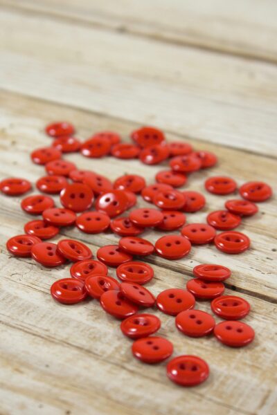 Boutons essentiel en plastique rouge vermillon Eglantine et Zoé à coudre sur des chemises, blouses et robes